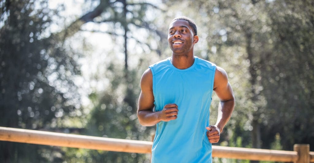 Man jogging next to country fence