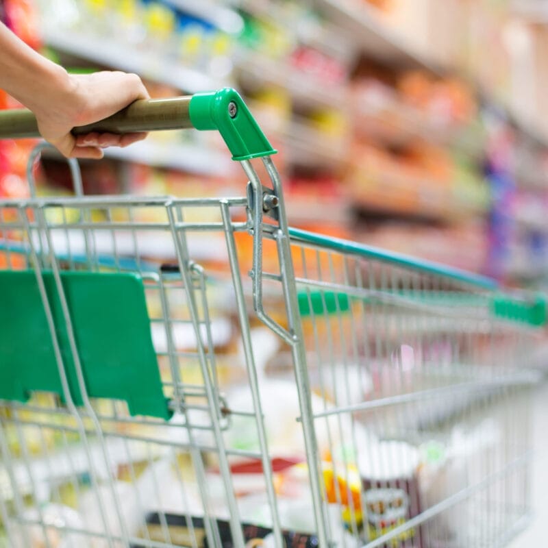 hand holding shopping cart in market