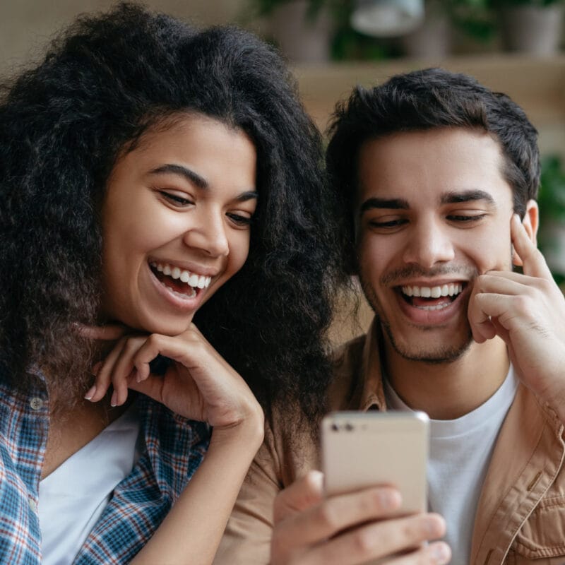 couple smiling in front of smartphone about health care incentives