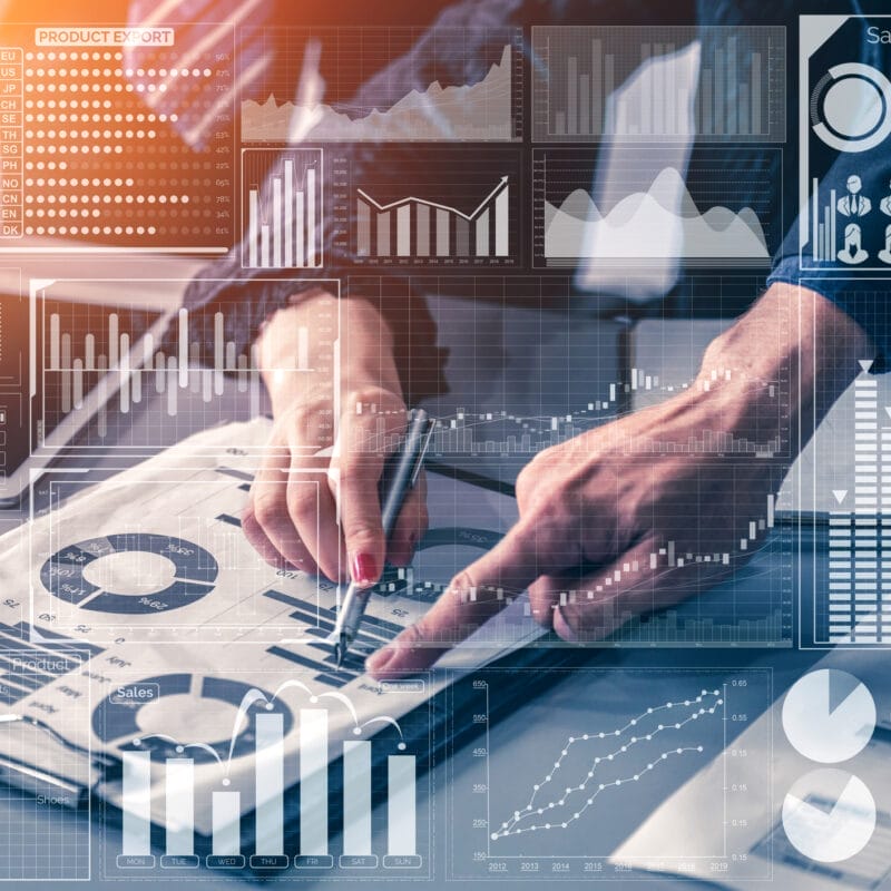 hands pointing at report with analytics charts overlayed