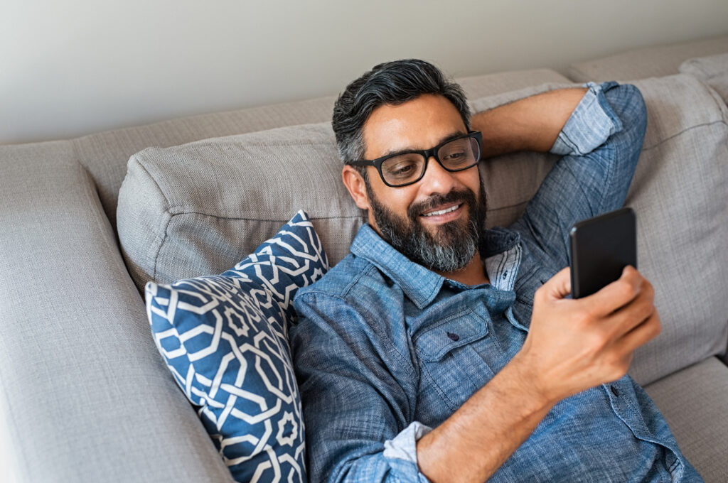 man on phone searching for healthcare price transparency at home